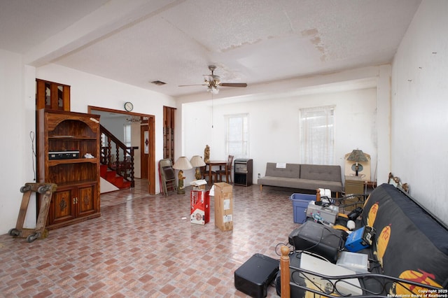 living room with a textured ceiling and ceiling fan