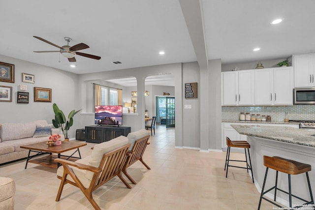 living room featuring ceiling fan and light tile patterned flooring