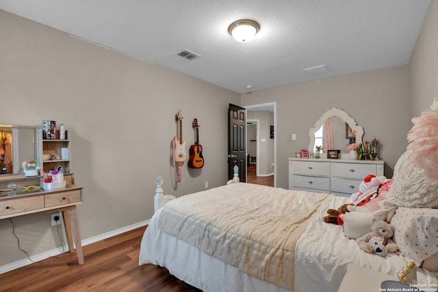 bedroom featuring a textured ceiling and dark hardwood / wood-style floors