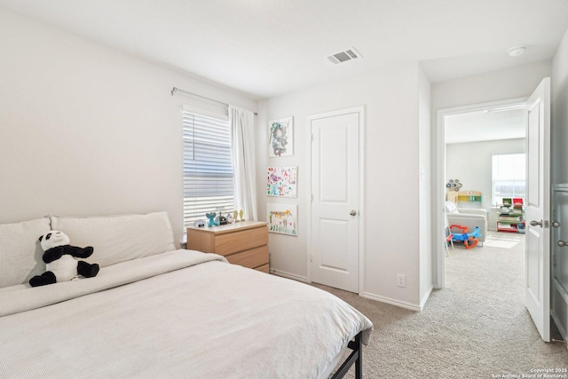 carpeted bedroom with multiple windows