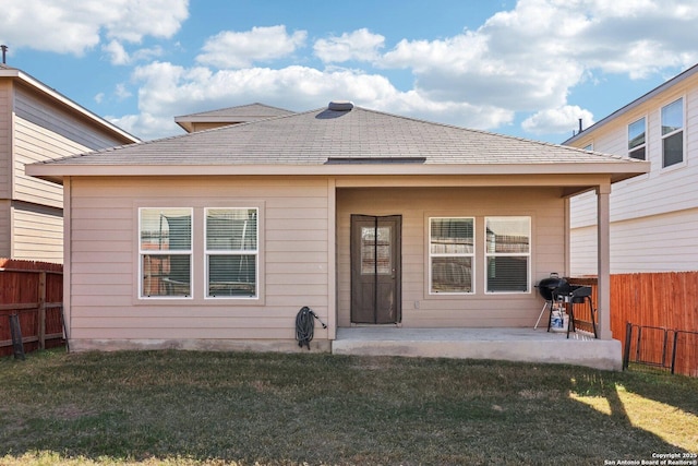 rear view of house featuring a lawn and a patio