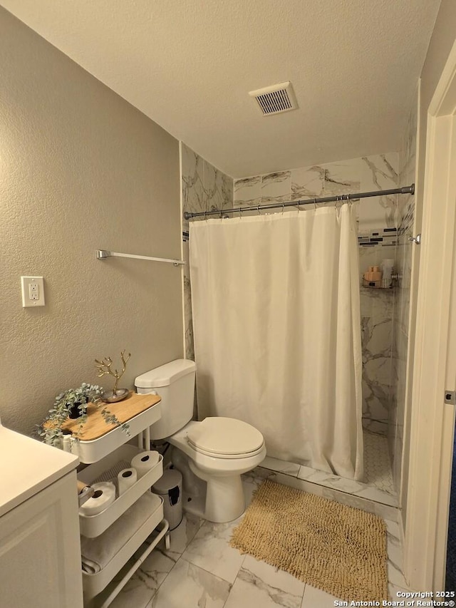 bathroom featuring a shower with shower curtain, vanity, a textured ceiling, and toilet