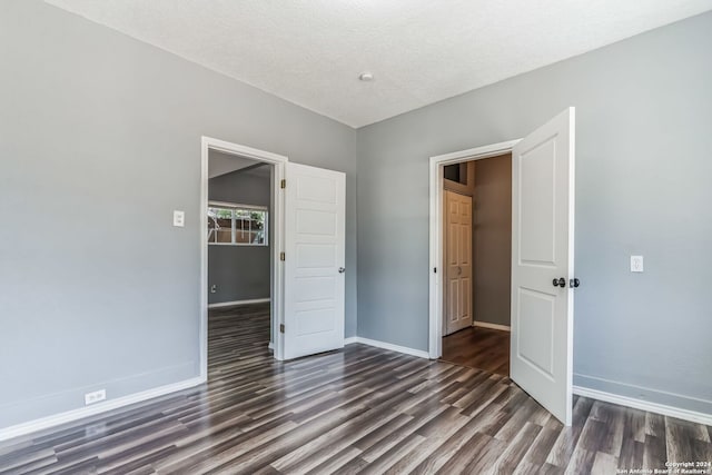 unfurnished bedroom with dark hardwood / wood-style flooring and a textured ceiling