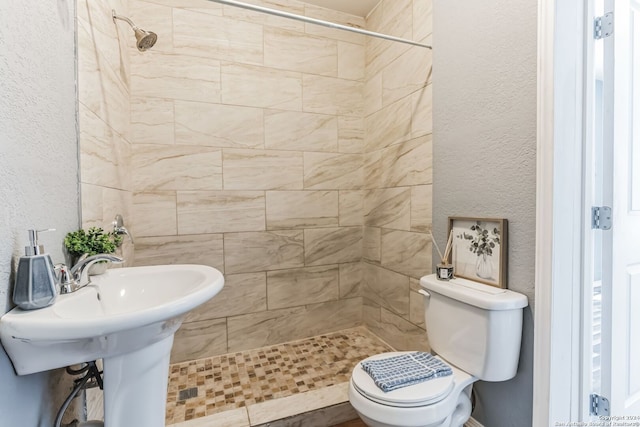 bathroom with tiled shower and toilet