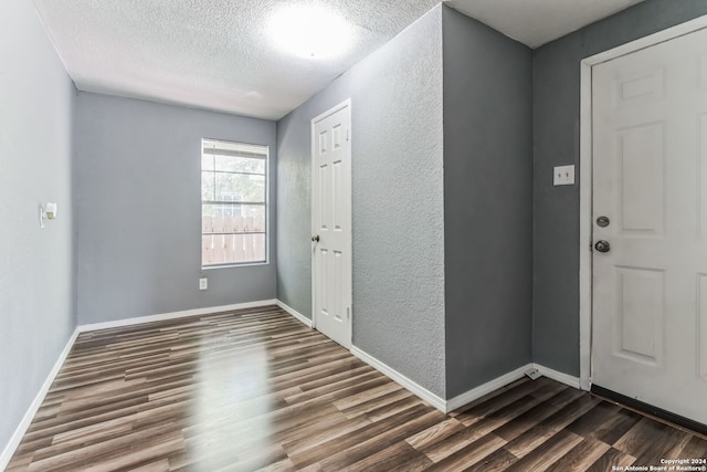 foyer entrance featuring dark hardwood / wood-style floors and a textured ceiling