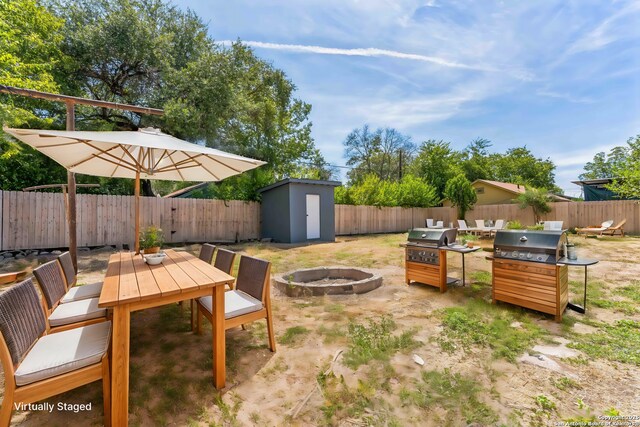 view of patio / terrace featuring a shed, grilling area, and a fire pit