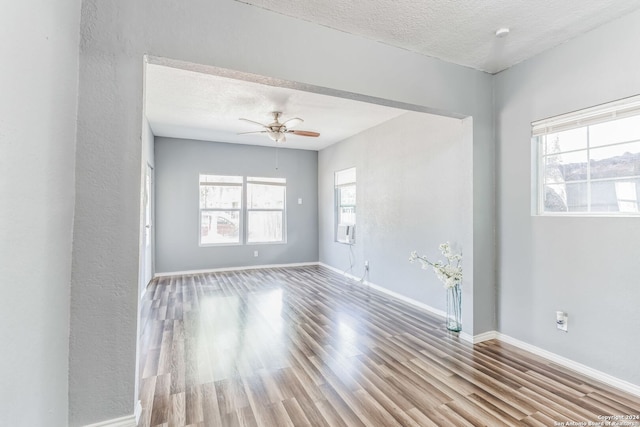 empty room featuring light wood-type flooring, a textured ceiling, and ceiling fan