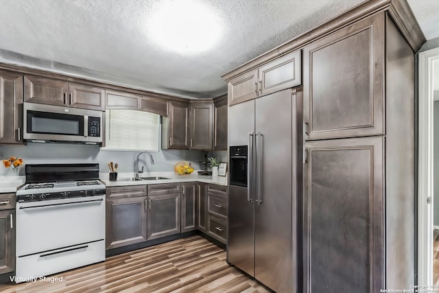 kitchen with dark brown cabinets, sink, and stainless steel appliances