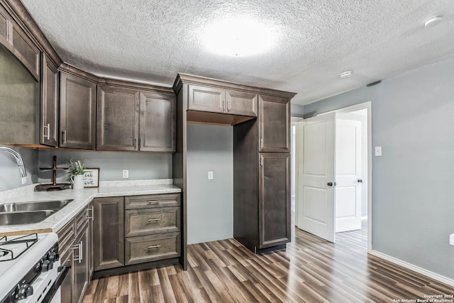 kitchen with dark brown cabinetry, dark wood-type flooring, and sink