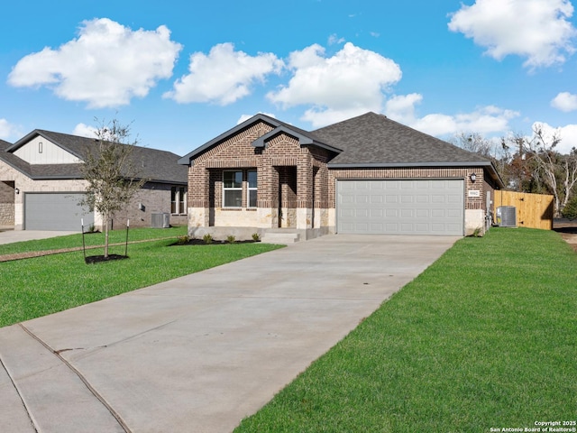 view of front of home with a front yard, a garage, and central air condition unit