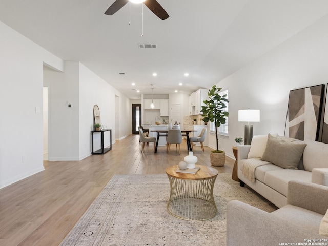 living room featuring light hardwood / wood-style flooring and ceiling fan