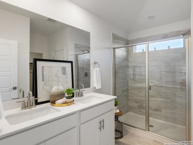 bathroom with vanity and a shower with door