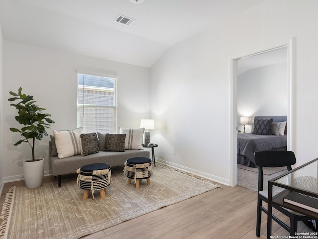 living room with light wood-type flooring and vaulted ceiling