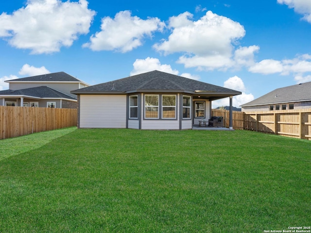 rear view of property with a yard and a patio