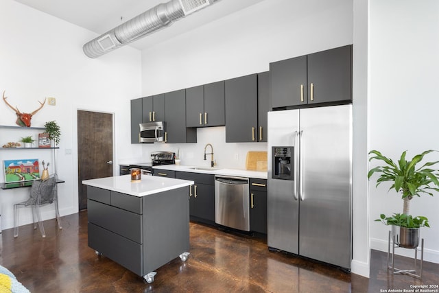 kitchen featuring gray cabinetry, sink, a kitchen island, and appliances with stainless steel finishes