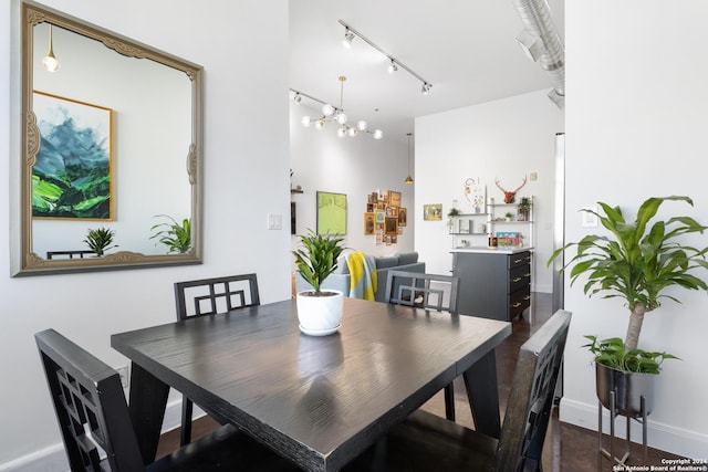 dining area featuring rail lighting and an inviting chandelier