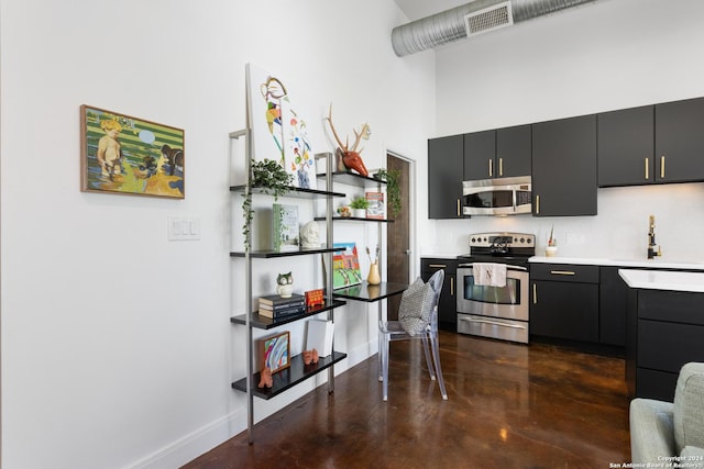 kitchen with appliances with stainless steel finishes, a high ceiling, and sink