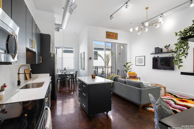 kitchen with a center island, an inviting chandelier, sink, decorative light fixtures, and stainless steel appliances