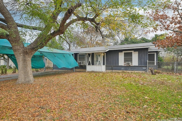 ranch-style home featuring a front lawn and a sunroom