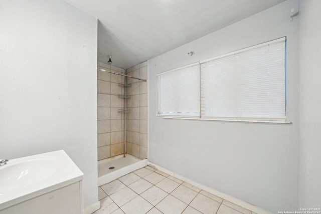 bathroom featuring tile patterned floors, vanity, and a tile shower