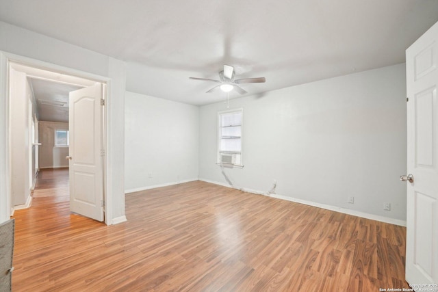 empty room with ceiling fan and light hardwood / wood-style flooring