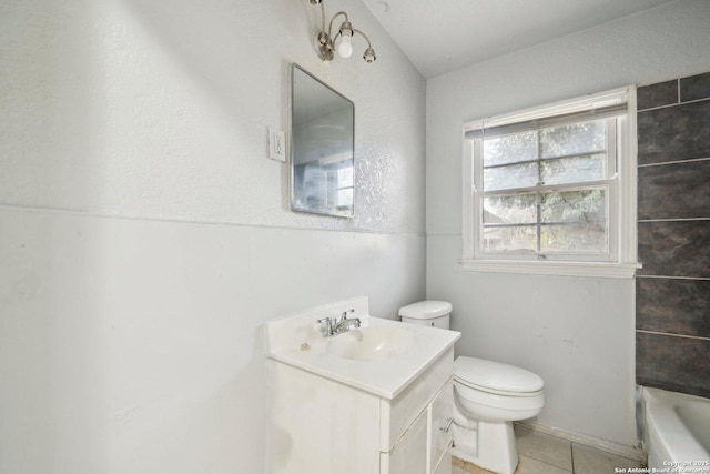 bathroom with tile patterned flooring, a washtub, vanity, and toilet