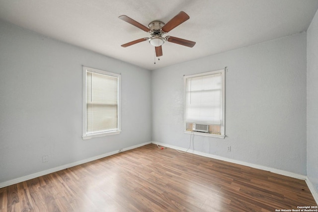 empty room with ceiling fan and dark hardwood / wood-style flooring