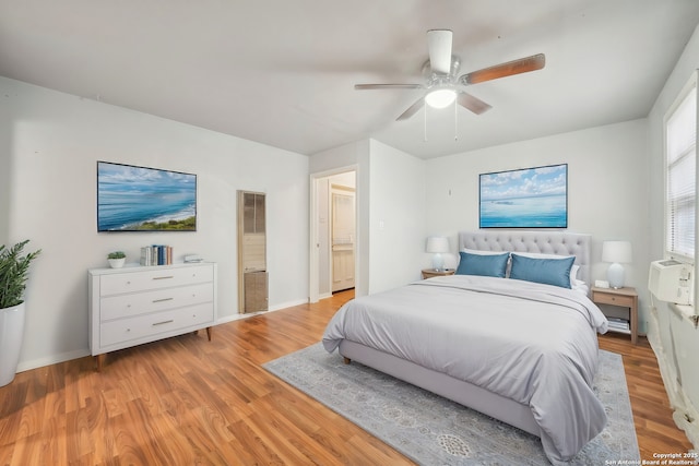 bedroom featuring light wood-type flooring, ensuite bath, and ceiling fan