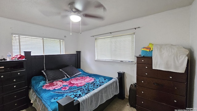 tiled bedroom featuring ceiling fan