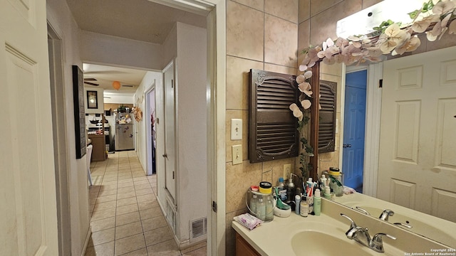 bathroom featuring tile patterned flooring, vanity, and tile walls