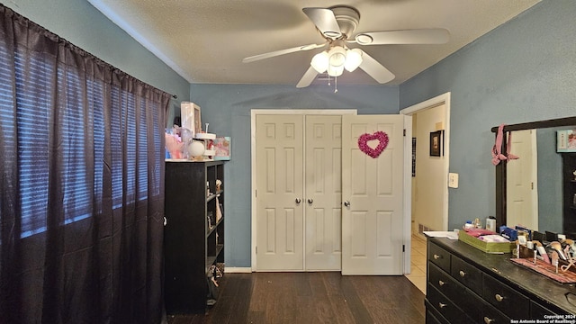 bedroom with a closet, dark hardwood / wood-style floors, and ceiling fan