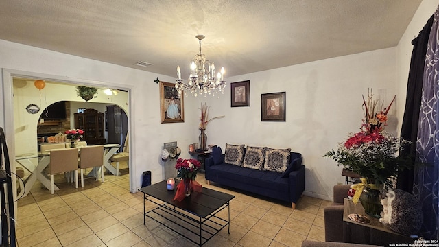 tiled living room with a textured ceiling and an inviting chandelier