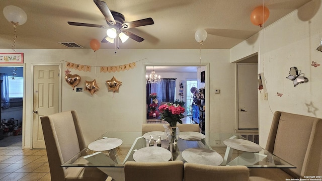 tiled dining space featuring ceiling fan with notable chandelier