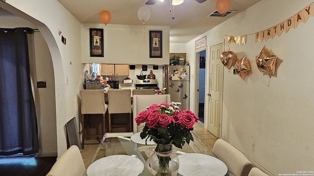 tiled dining room featuring ceiling fan