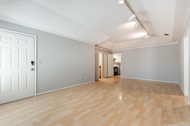 unfurnished living room featuring track lighting, vaulted ceiling, ornamental molding, and light hardwood / wood-style floors