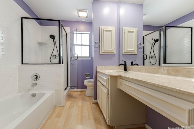 full bathroom with hardwood / wood-style floors, vanity, toilet, and independent shower and bath