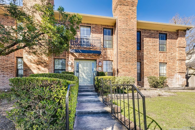 view of front of house with a front yard and a balcony