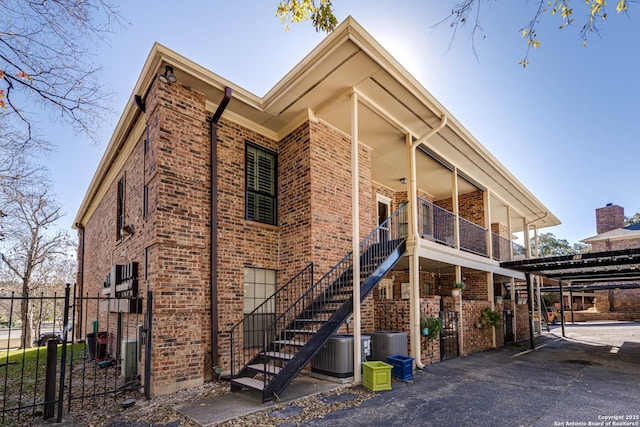 exterior space featuring a balcony, a carport, and cooling unit