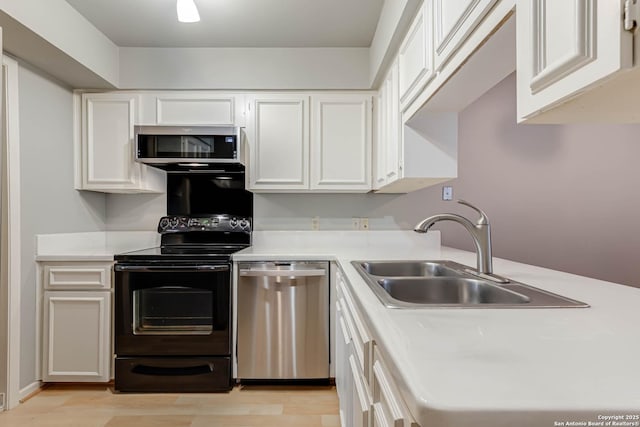 kitchen featuring white cabinets, stainless steel appliances, light hardwood / wood-style floors, and sink