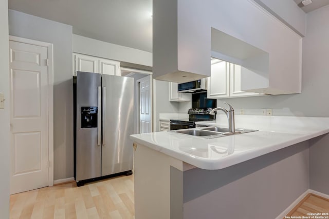 kitchen featuring black range with electric stovetop, sink, stainless steel fridge, white cabinetry, and kitchen peninsula