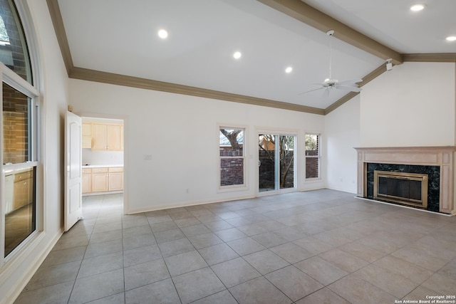 unfurnished living room with lofted ceiling with beams, ceiling fan, a premium fireplace, ornamental molding, and light tile patterned flooring