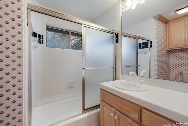 bathroom featuring vanity and enclosed tub / shower combo