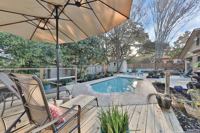 view of pool featuring a shed and a deck