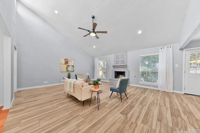 living room featuring high vaulted ceiling, a brick fireplace, and ceiling fan