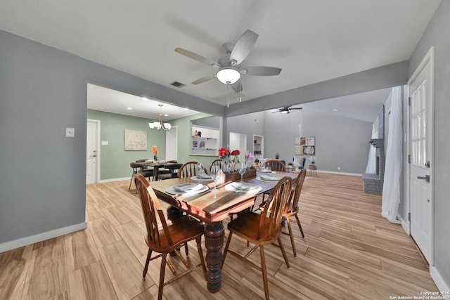 dining area featuring ceiling fan with notable chandelier and light hardwood / wood-style floors