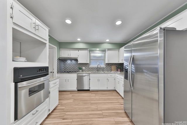 kitchen featuring light stone countertops, sink, decorative backsplash, white cabinets, and appliances with stainless steel finishes