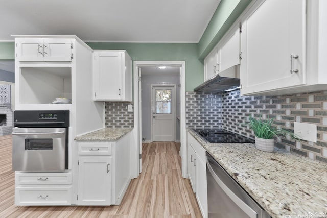 kitchen with decorative backsplash, appliances with stainless steel finishes, white cabinetry, and light stone counters