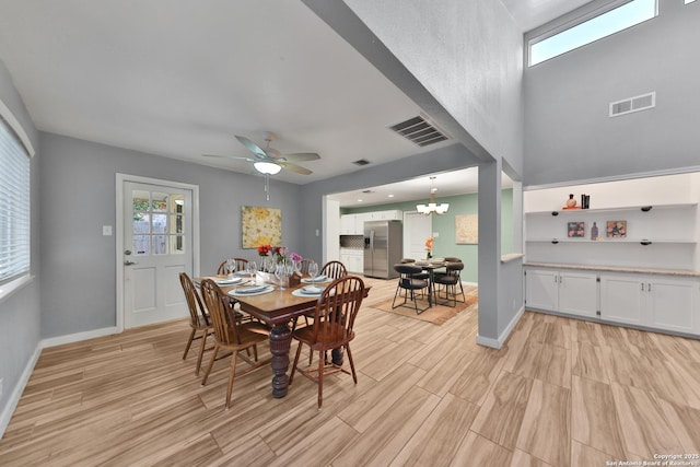 dining area featuring ceiling fan with notable chandelier