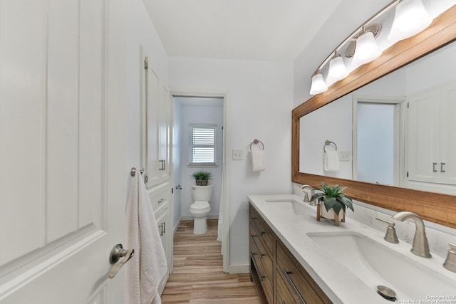 bathroom featuring wood-type flooring, vanity, and toilet