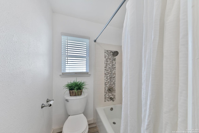 bathroom featuring shower / bath combo and toilet